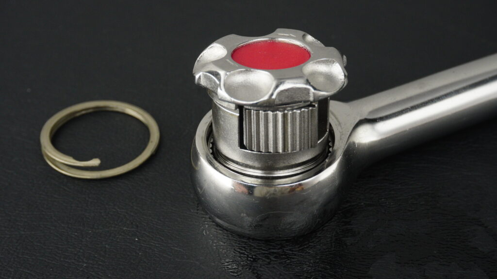 TONE（トネ）製ステンレスラチェット SRH31。ギアから露出した「楔（くさび）式」パウルと、隣に置かれた固定用クリップ。