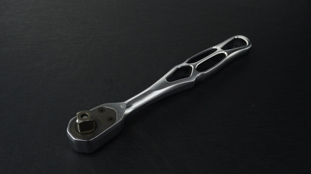 黒い背景に置かれたKTC nepros neXT NBR390Xラチェットハンドル。特徴的な肉抜き構造のトポロジーグリップと背面のディテール。