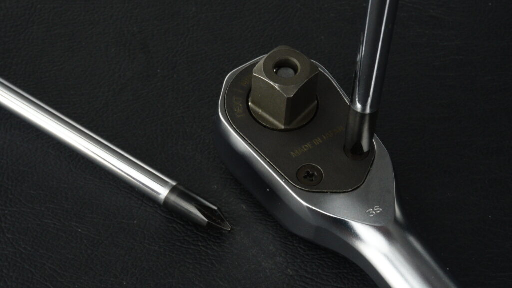 KTC nepros neXT NBR390Xのカバープレートを留めるプラスネジと、それに当てられたドライバーの先端。